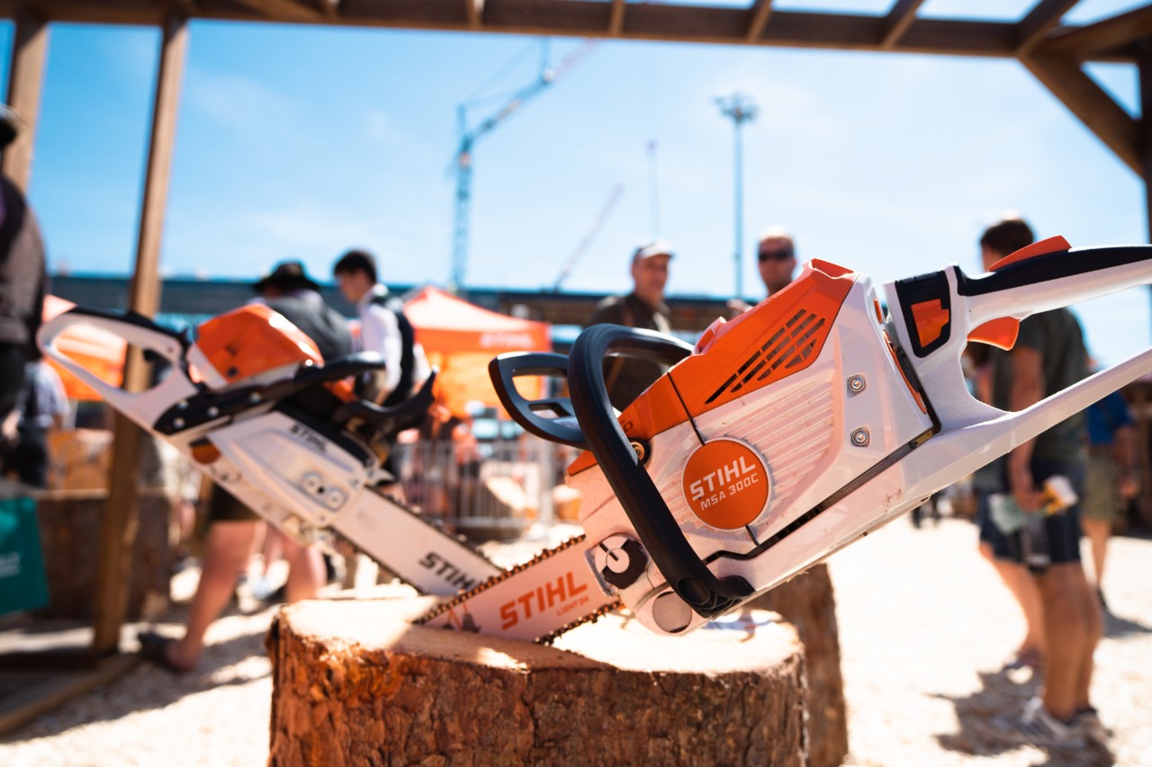 STIHL chainsaws, including the MSA 300 C, on an outdoor trade fair stand.