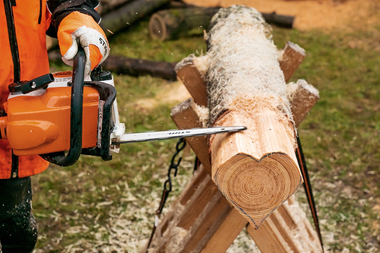 Make flat heart slices from a log: edges of the wooden heart being smoothed with a STIHL MS 170 petrol chainsaw