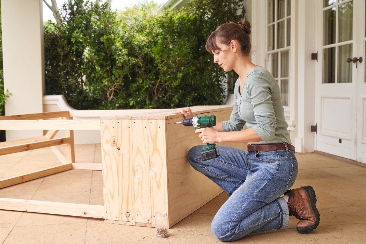 Woman on a terrace fitting the floor for the greenhouse