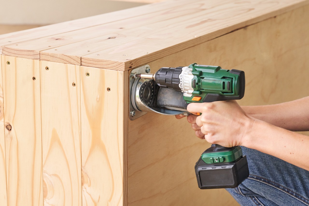 Close-up of a woman screwing castors onto the tomato house floor