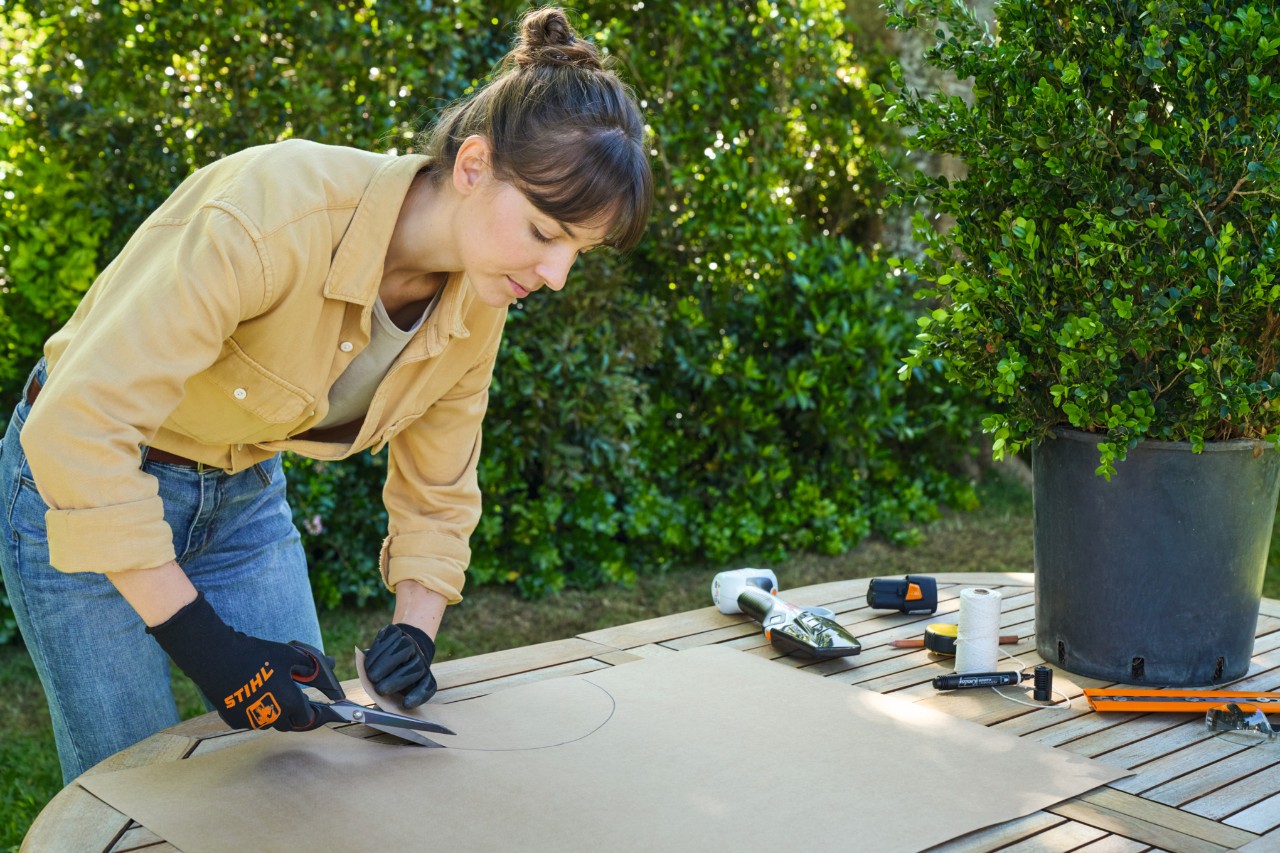 A woman cutting out a pre-drawn semicircle with scissors